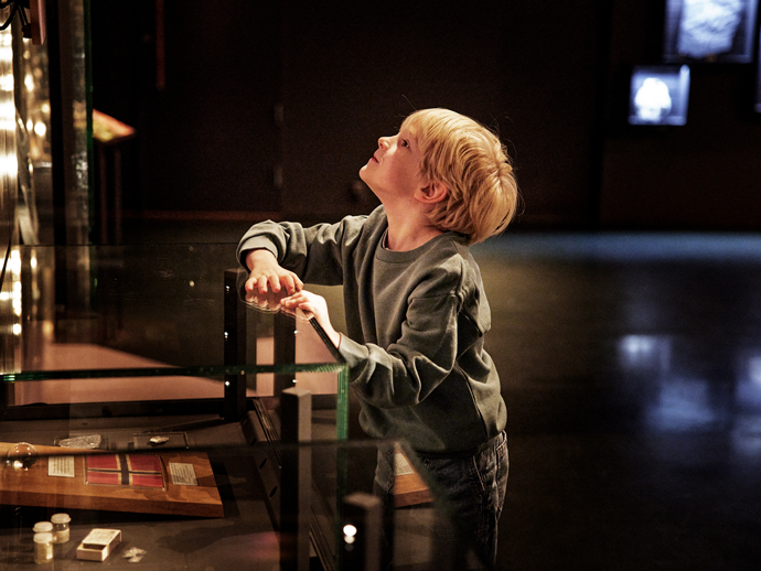 barn titter inn i monter i utstilling på museum
