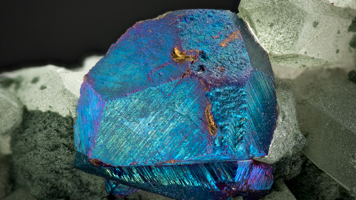 blå krystall med omrkingliggende stein