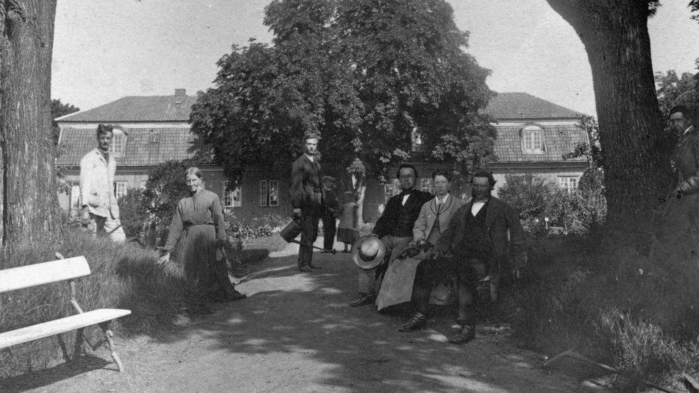 Bestyrer i Botanisk hage Frederik Schübeler omgitt av ansatte i hagen på parkbenbkjer