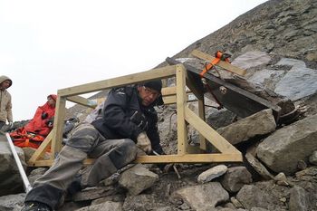 Nils-Petter Bergersen snekrer treplattform som skal sikre at fossilsteinen står trygt til den kan graves ut av snøen.&amp;#160;Foto: Hans Arne Nakrem