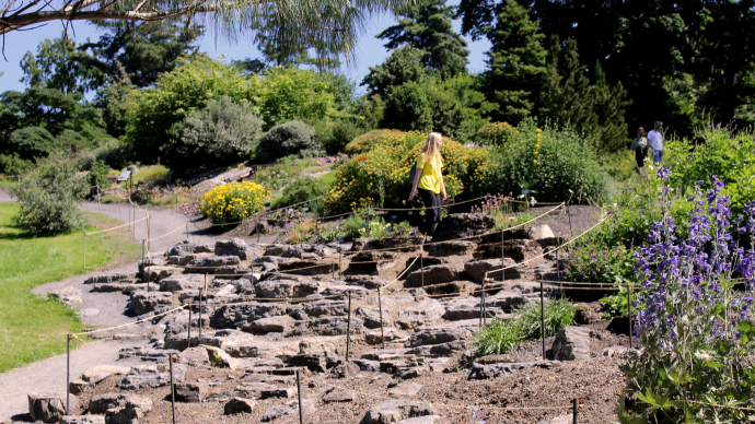 Bilde av et hageparti med stein og bed som ennå ikke er beplantet.