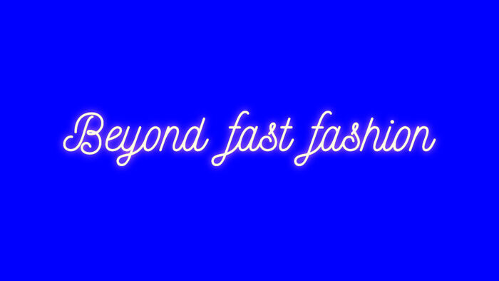 neon skrift på blå bakgrunn tekst: beyond fast fashion